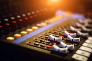 A close up of a sound mixer with multiple volume switches